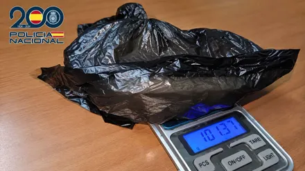 Pesa y bolsa negra con sustancias estupefacientes.