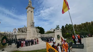 Bandera de España izada ante el Monumento a la Constitución de 1812, en la plaza de España de Cádiz, con autoridades y miembros de la Guardia Civil situados frente al monumento durante el acto inaugural de la Semana de la Guardia Civil.