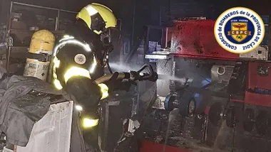 Vivienda incendiada y bombero trabajando en su interior.