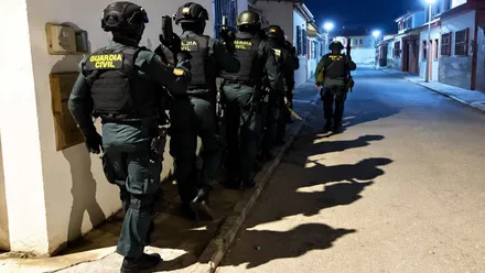 Fila con muchos agentes de la Guardia Civil, en la noche, a punto de acceder a una vivienda sospechosa de narcotráfico.