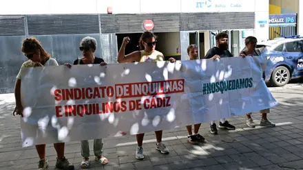 Fani y representantes del Sindicato de Inquilinas de Cádiz sostienen una gran pancarta frente a los juzgados con el lema «Sindicato de Inquilinas e Inquilinos de Cádiz» y «#NosQuedamos».