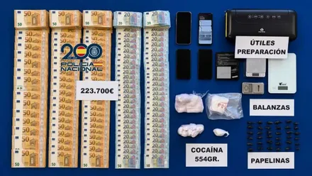 Mesa, con fondo azul, y el material incautado por la Policía Nacional.
