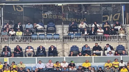 Vista con zoom del palco presidencial del estadio Nuevo Mirandilla tomada desde la grada de Preferencia durante el Cádiz-Girona. En las diferentes filas aparecen autoridades, invitados y otros asistentes, con varios asientos vacíos en la zona central del palco.