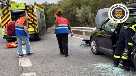 Camión de bomberos y coche accidentado junto a un médico.