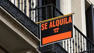 Cartel en negro y naranja en un balcón de una vivienda.