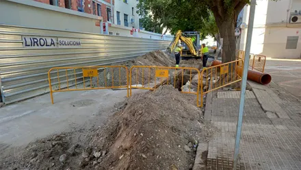 Operarios y una máquina excavadora trabajan en una zanja abierta durante las obras de mejora de la red de aguas pluviales en el Cerro del Moro de Cádiz.