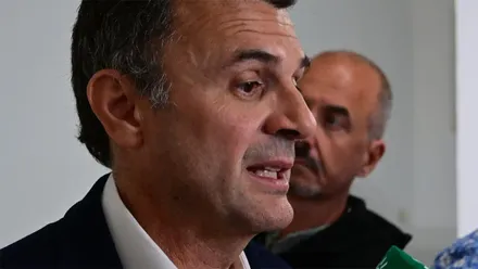Bruno García, vestido con chaqueta oscura y camisa blanca, responde a los periodistas rodeado de micrófonos de distintos medios de comunicación, entre ellos laSexta, RNE y TVE.