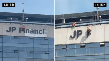 Varios operarios trabajan en altura sobre la fachada de Tribuna del Nuevo Mirandilla, donde todavía permanecen instaladas las letras de gran tamaño de JP Financial.