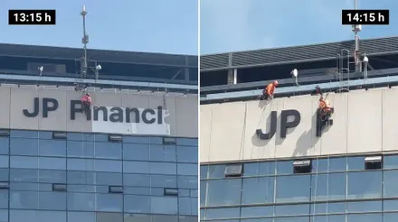 Varios operarios trabajan en altura sobre la fachada de Tribuna del Nuevo Mirandilla, donde todavía permanecen instaladas las letras de gran tamaño de JP Financial.