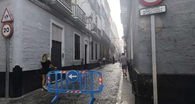 calle de Cádiz cortada para el acceso a un colegio bajo un cielo con algunas nubes.