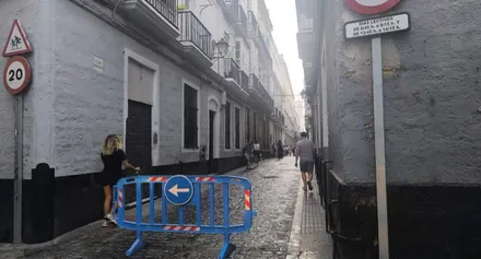 calle de Cádiz cortada para el acceso a un colegio bajo un cielo con algunas nubes.