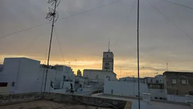 La Torre Tavira de Cádiz parece dibujada sobre un cielo nublado y con los primeros rayos del sol cerca del horizonte