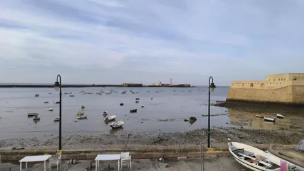 Vista de la playa de La Caleta de Cádiz con el castillo de San Sebastián al fondo.