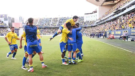 Varios futbolistas del Cádiz CF se abrazan junto a la banda durante la celebración de un gol en la victoria por 3-1 ante la AD Ceuta.