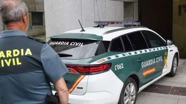 Vehículo y un agente de la Guardia Civil.