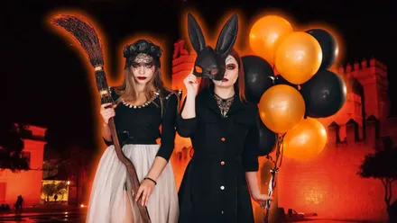Castillo de El Puerto y dos chicas disfrazadas para Halloween, destaca el color negro y naranja.
