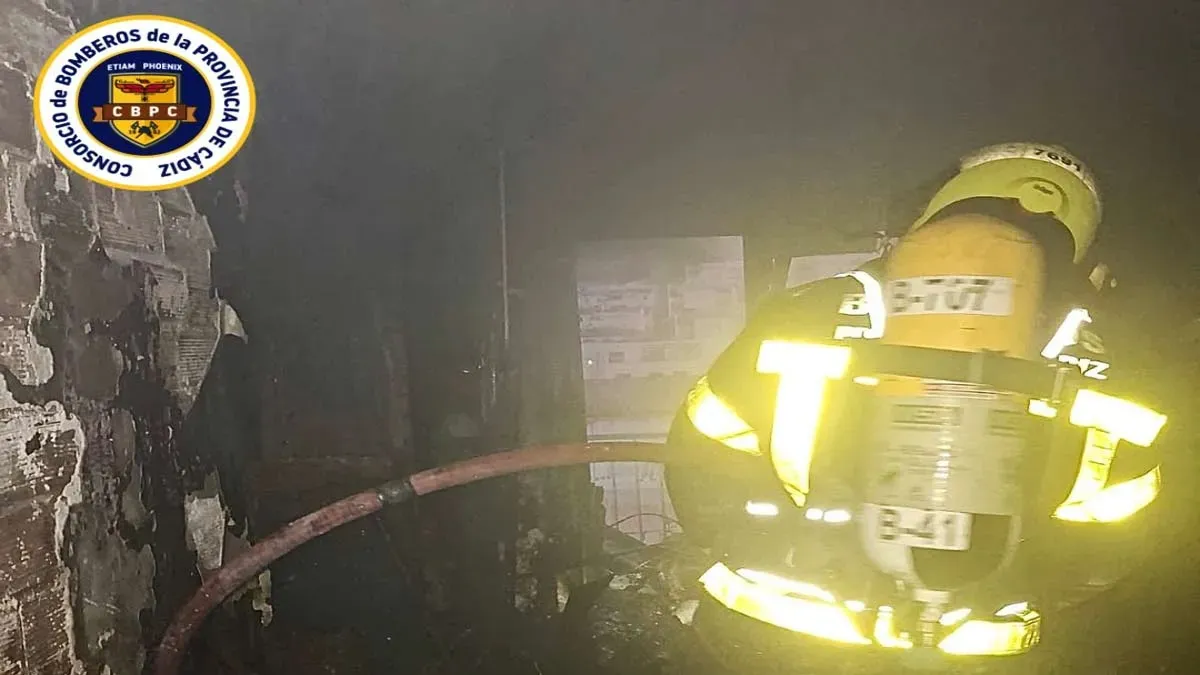 Piso incendiado y un bombero en su interior con ropa reflectante y equipo de respiración.