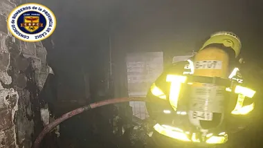 Piso incendiado y un bombero en su interior con ropa reflectante y equipo de respiración.