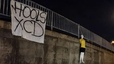 Muñeco con la camiseta amarilla del Cádiz CF colgado de un puente y una cartel de los ultras del Xerez.