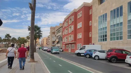 Vista del paseo por Santa María del Mar con el edificio de fachada roja donde se encuentra la vivienda puesta a la venta por 990.000 euros.