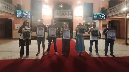 Representantes sindicales muestran carteles reivindicativos en el hall del Gran Teatro Falla de Cádiz durante la inauguración del FIT.