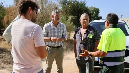 Cuatro personas hablan en un camino de arena de Rota.
