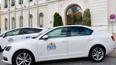 Dos taxis aparcados en El Puerto. Son de color blanco.