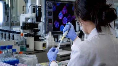 Chica trabajando en un laboratorio haciendo ensayos.