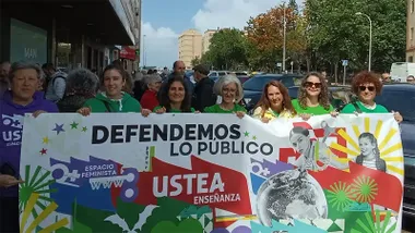 Varias personas participan en una movilización de Ustea sosteniendo una pancarta con el lema “Defendemos lo público” y el nombre de Ustea Enseñanza.