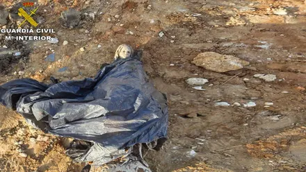 Imagen de la Virgen de Lourdes metida en una bolsa negra y desenterrada.