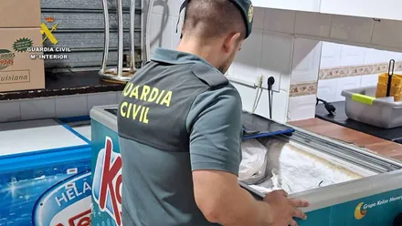 Un Guardia Civil procede a registran un arcón frigorífico con alimentos congelados.