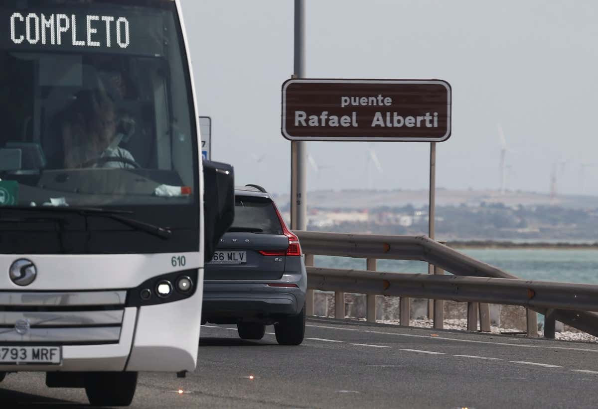 Rótulo con el nuevo nombre Puente Rafael Alberti y dos vehículos circulando por él.