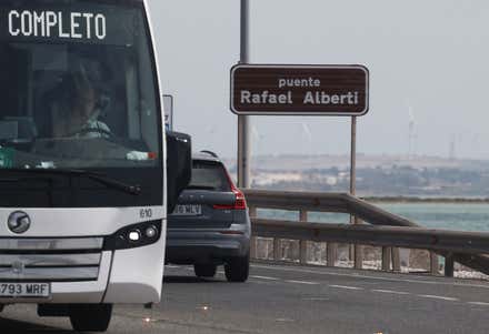 Rótulo con el nuevo nombre Puente Rafael Alberti y dos vehículos circulando por él.